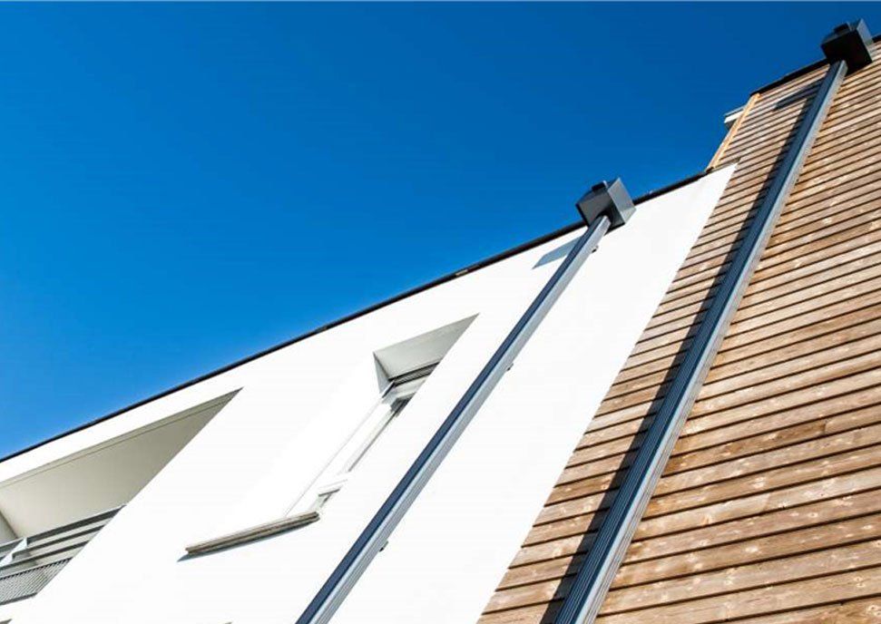 Descente d'eaux pluviales sur un bâtiment avec bardage