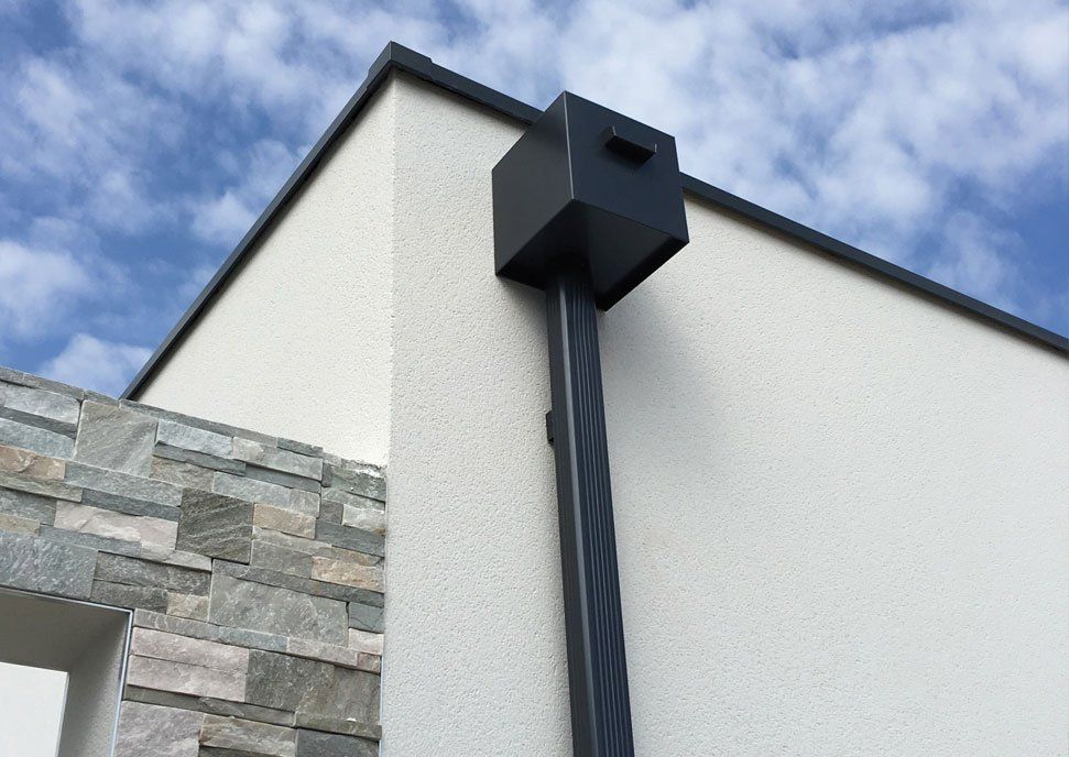 Boîte à eau noire sur un mur à couvertine