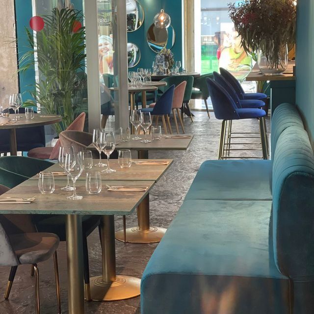 Un restaurante con mesas y sillas y un sofá azul.