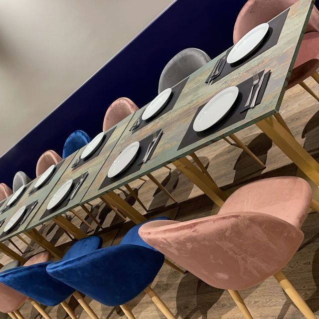 Una mesa larga con platos y cubiertos encima.