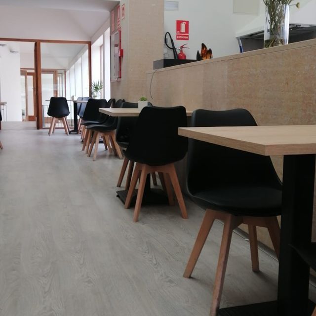 Una fila de mesas y sillas en un restaurante