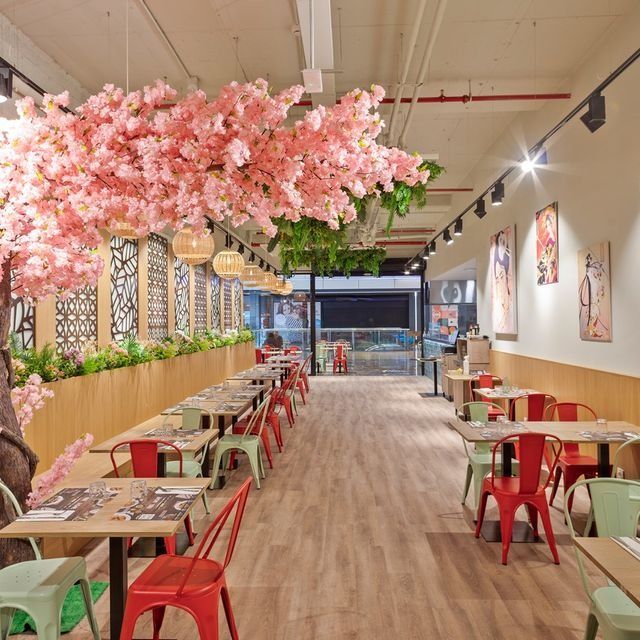 Un restaurante con flores rosas colgando del techo.