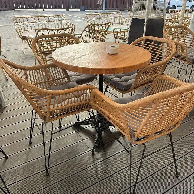 Una mesa y sillas de madera están colocadas sobre una terraza de madera.