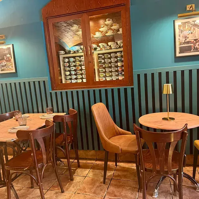 Un restaurante con mesas y sillas y una vitrina de vinos.