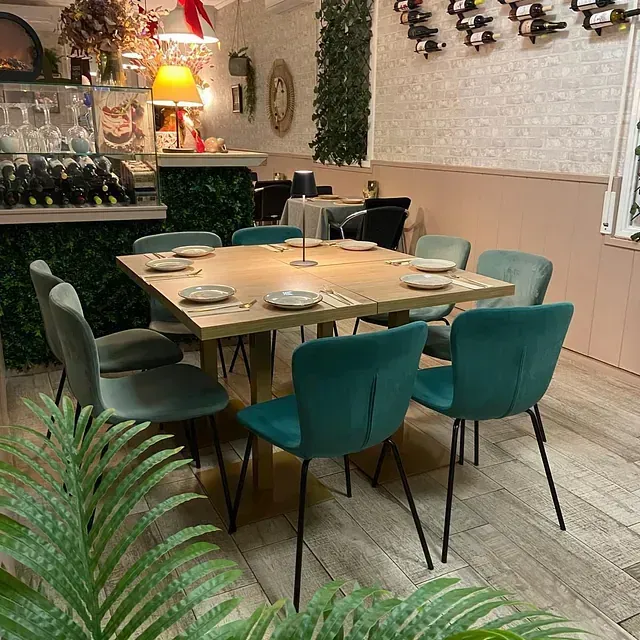 Un comedor con una mesa y sillas y platos encima.