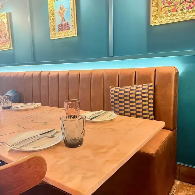 Una mesa en un restaurante con platos y vasos sobre ella.