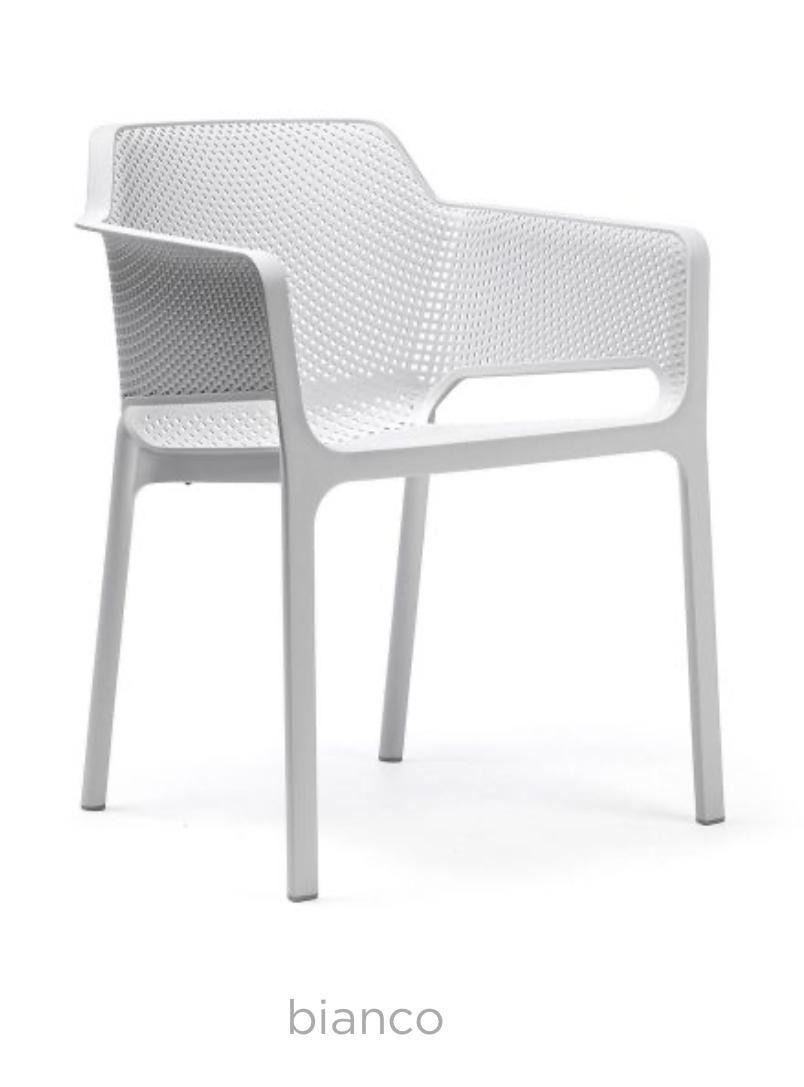 Una silla de plástico blanca está colocada sobre una superficie blanca.