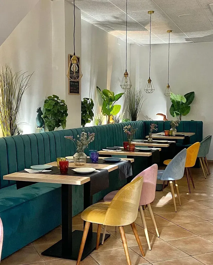 Hay muchas mesas y sillas en el restaurante.