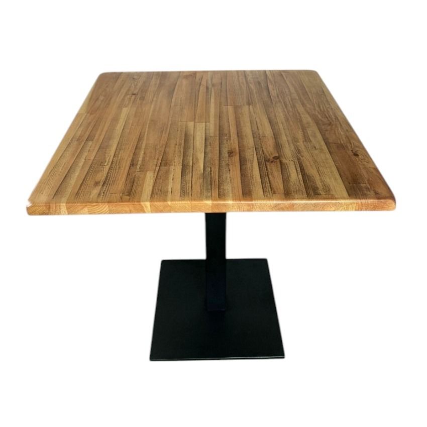 Una mesa cuadrada de madera con una base negra sobre un fondo blanco.