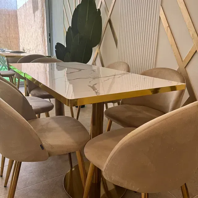 Una mesa y sillas en una habitación con una planta al fondo.
