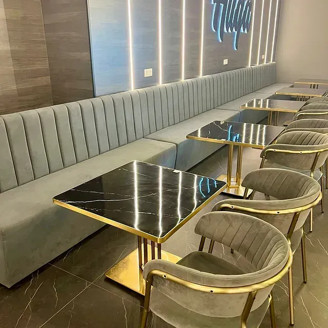 Una larga fila de mesas y sillas en un restaurante.