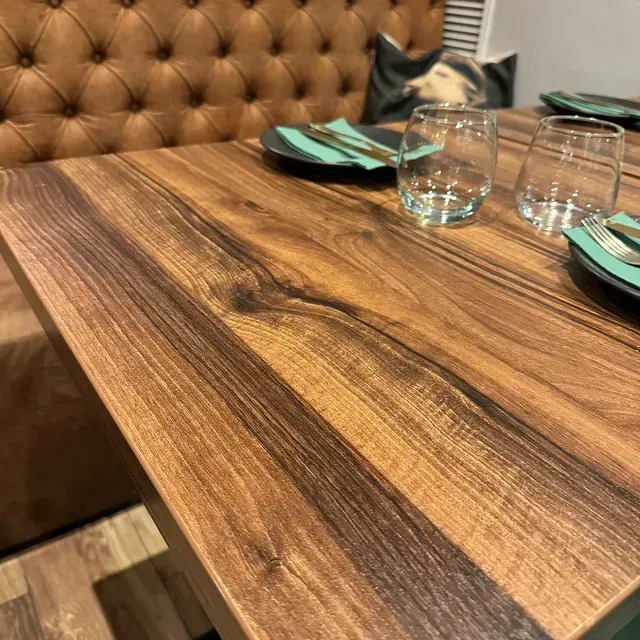 Una mesa de madera con platos y vasos encima.