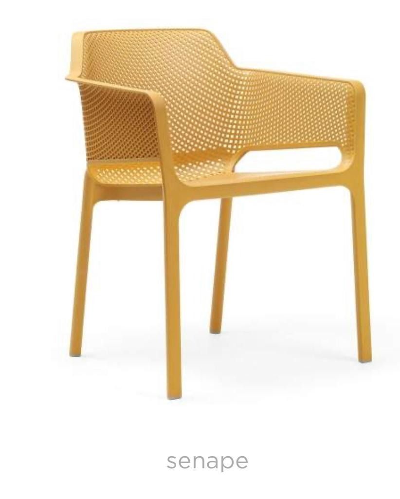 Una silla de plástico blanca está colocada sobre una superficie blanca.