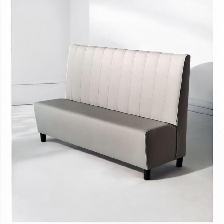 Un sofá rosa con patas negras está sentado sobre una superficie blanca.