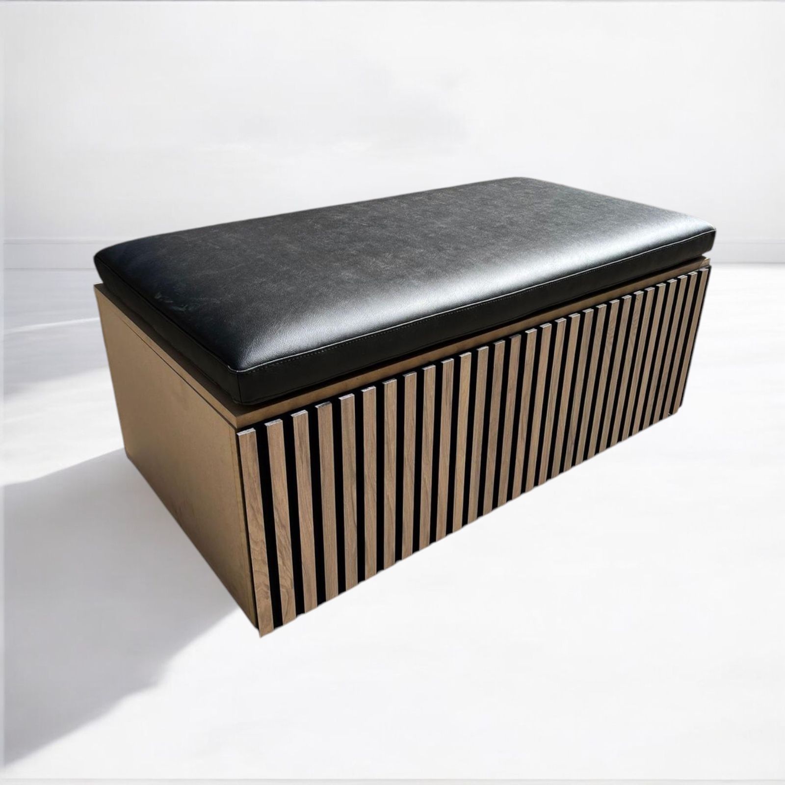 Un sofá largo y gris con listones de madera debajo.