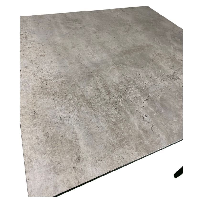 Una mesa con tablero de hormigón y patas negras