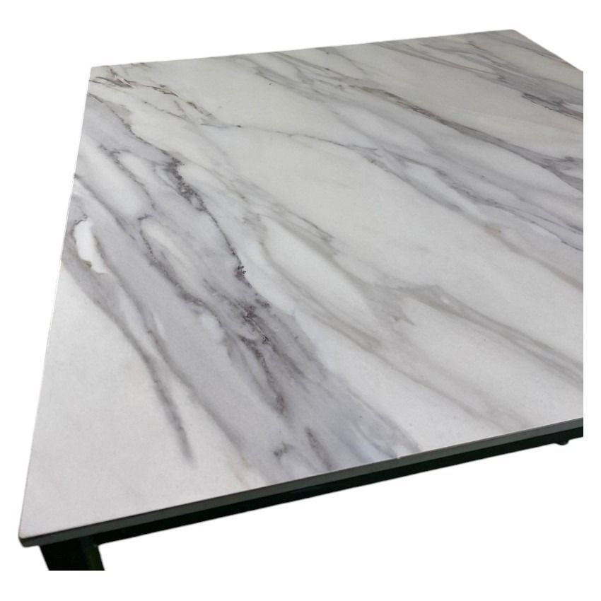 Una mesa de mármol blanco con patas negras sobre un fondo blanco.