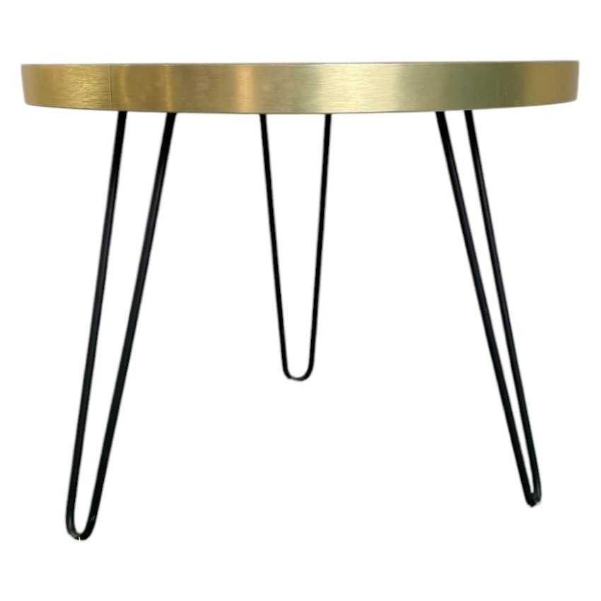 Una mesa redonda con tapa de mármol y patas de horquilla negras.