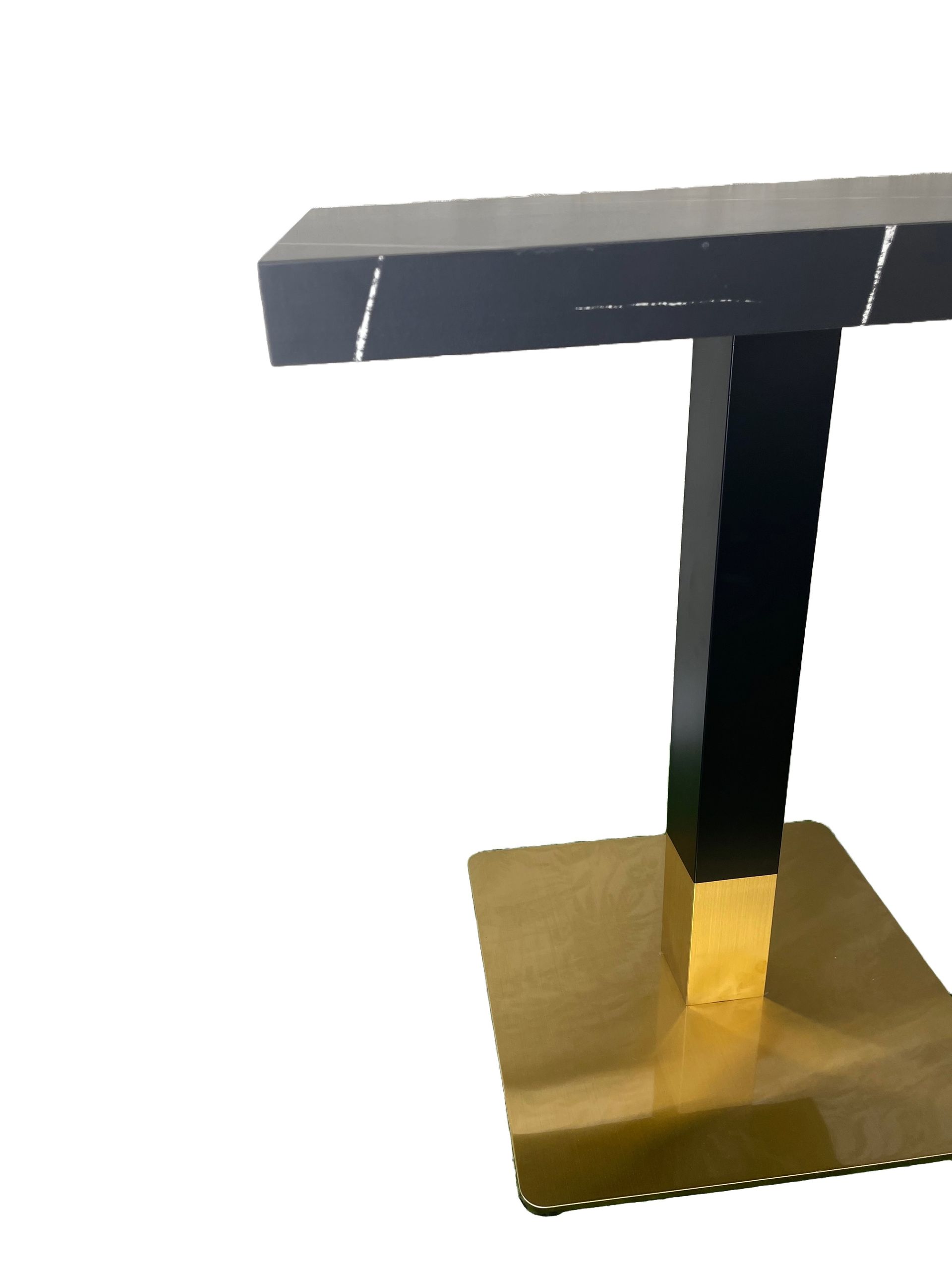Una mesa de mármol negro con base dorada sobre fondo blanco.