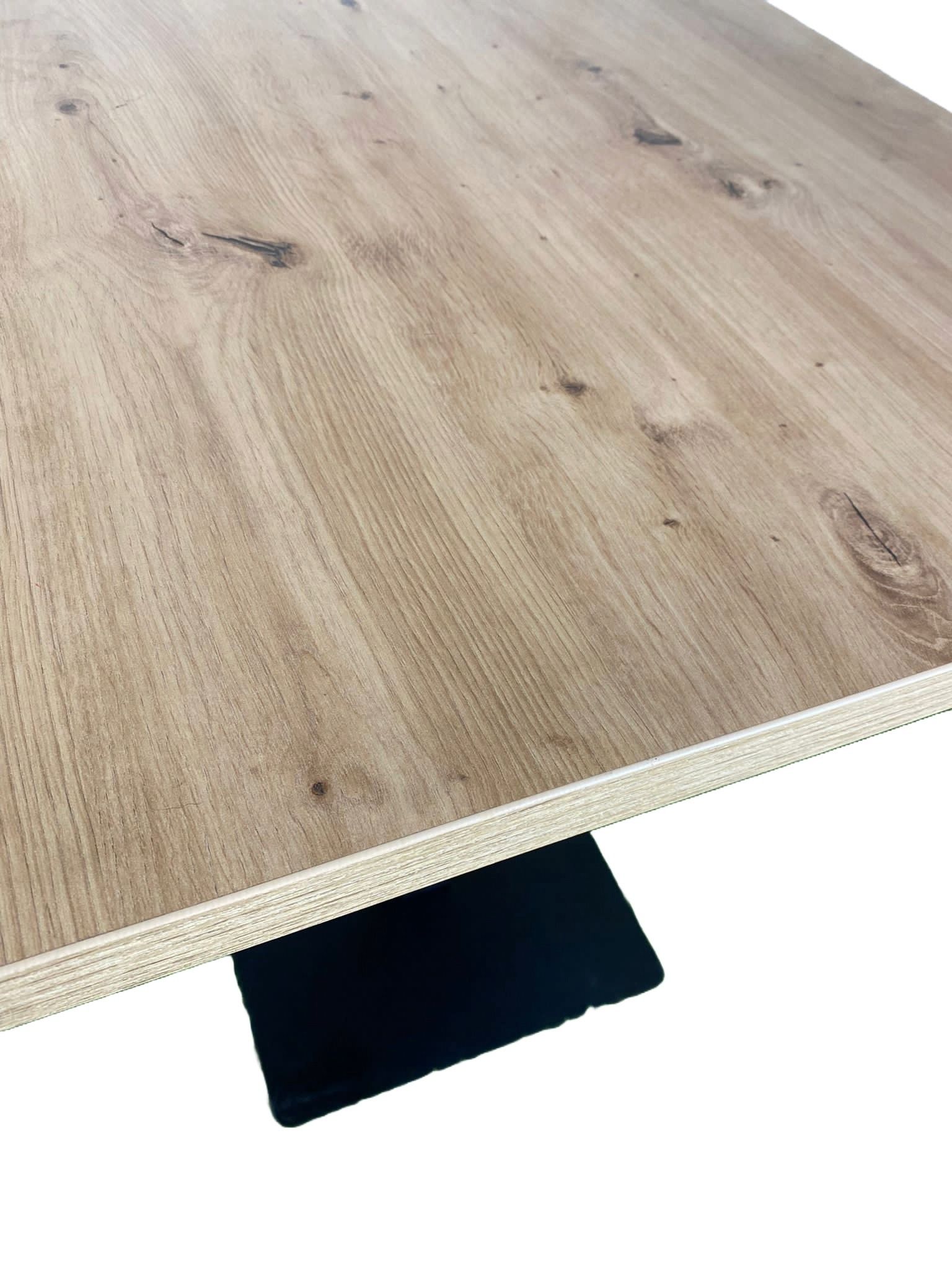 Una mesa cuadrada con tapa de madera y base negra.
