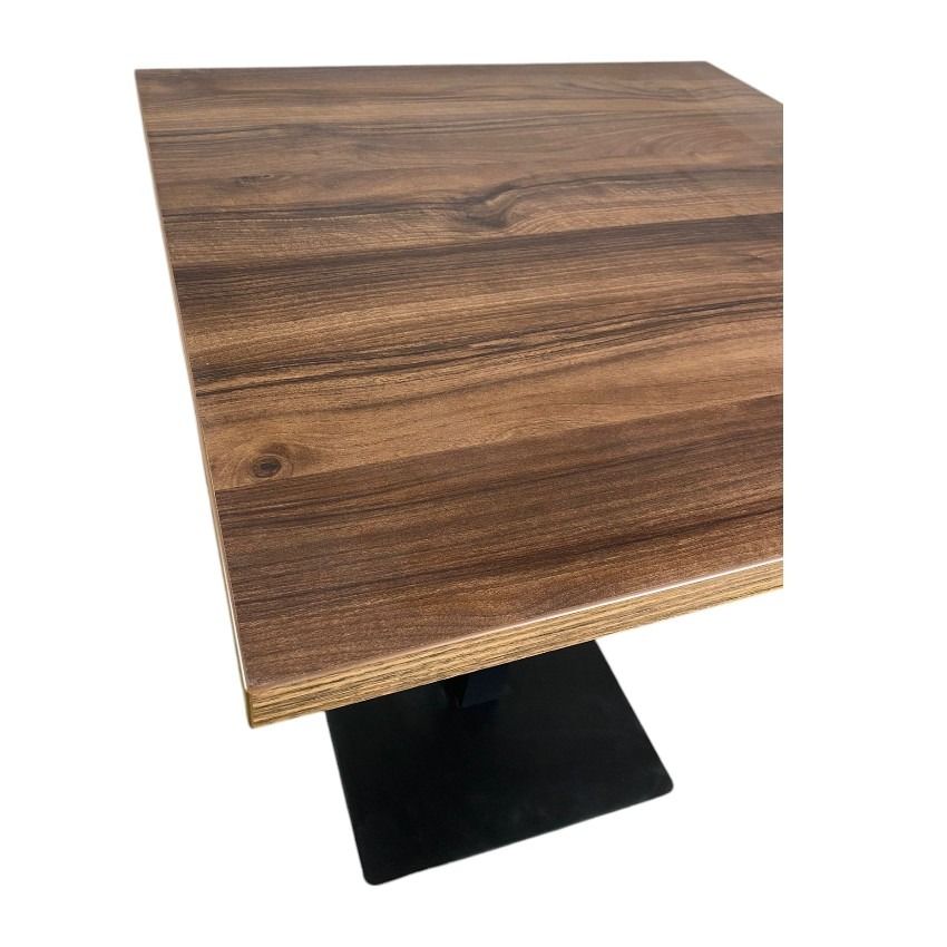 Una mesa cuadrada de madera con una base negra sobre un fondo blanco.