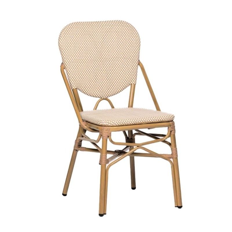 Una silla de mimbre con un cojín negro sobre un fondo blanco.