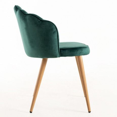 Una silla de terciopelo verde con patas doradas sobre un fondo blanco.