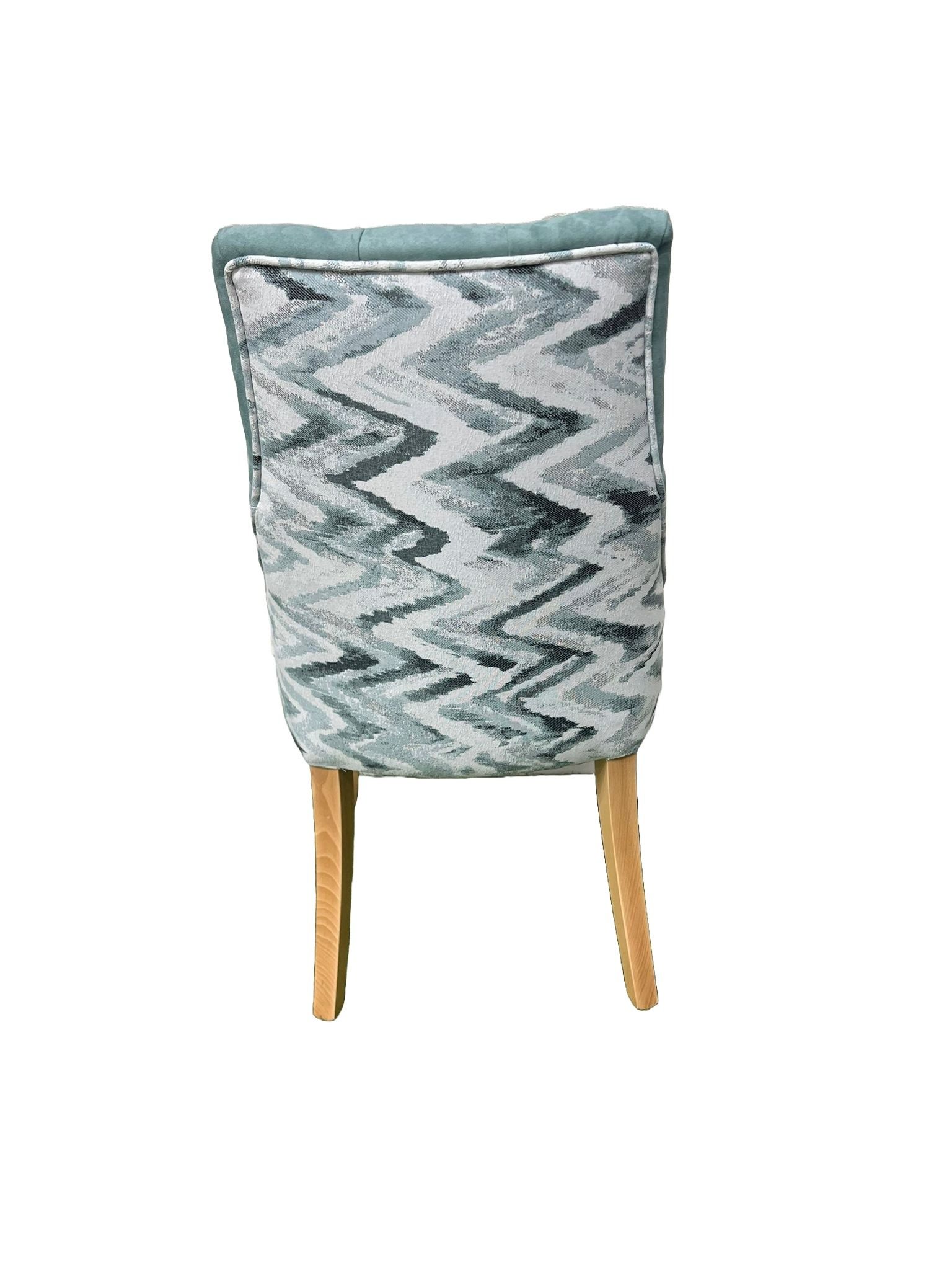 Una silla azul con patas de madera sobre un fondo blanco.