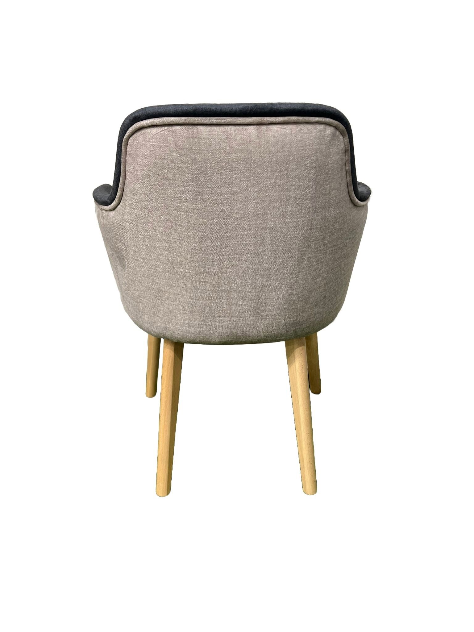 Una silla negra con patas de madera sobre un fondo blanco.