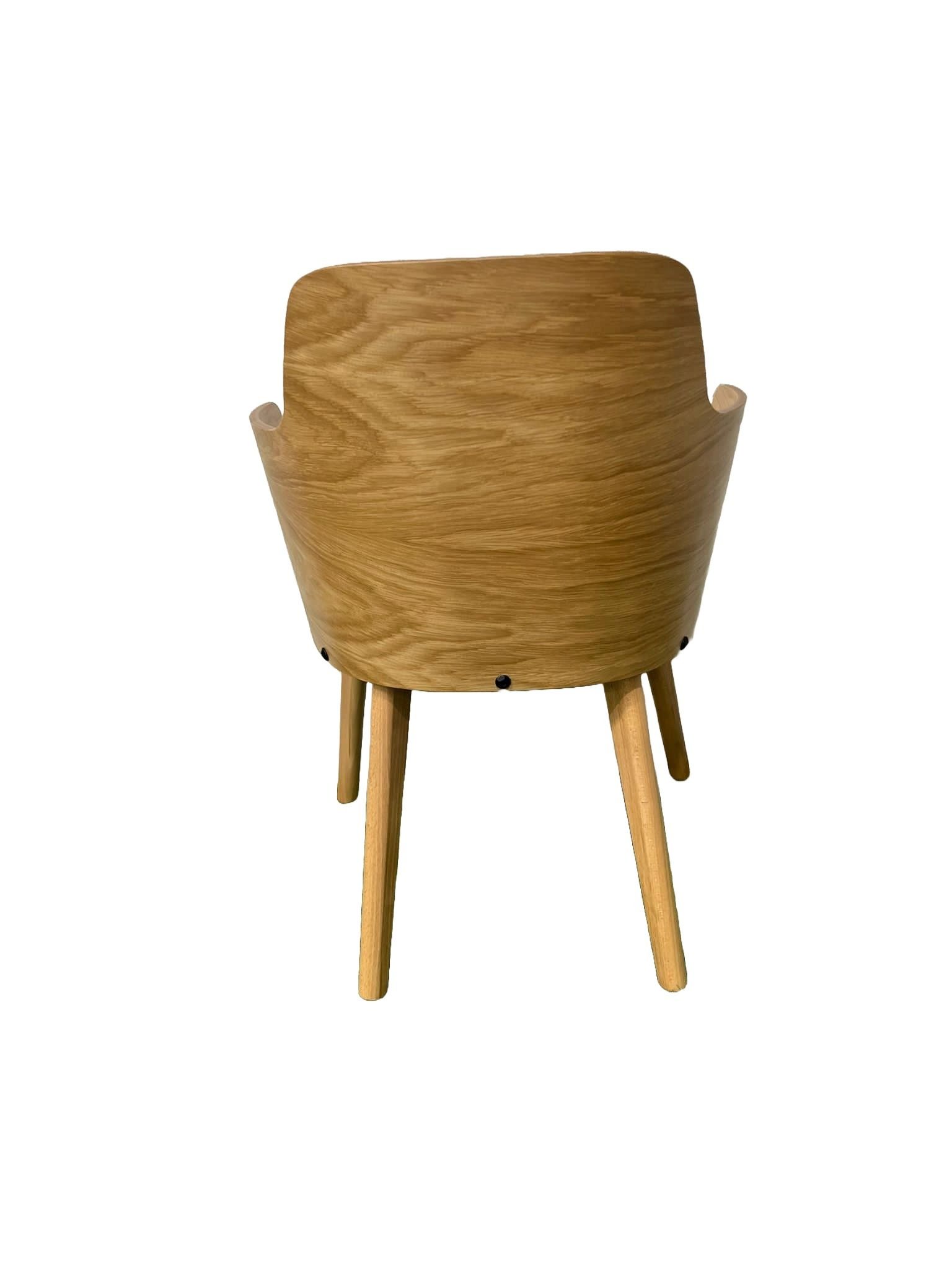 Una silla de madera con un cojín blanco sobre un fondo blanco.