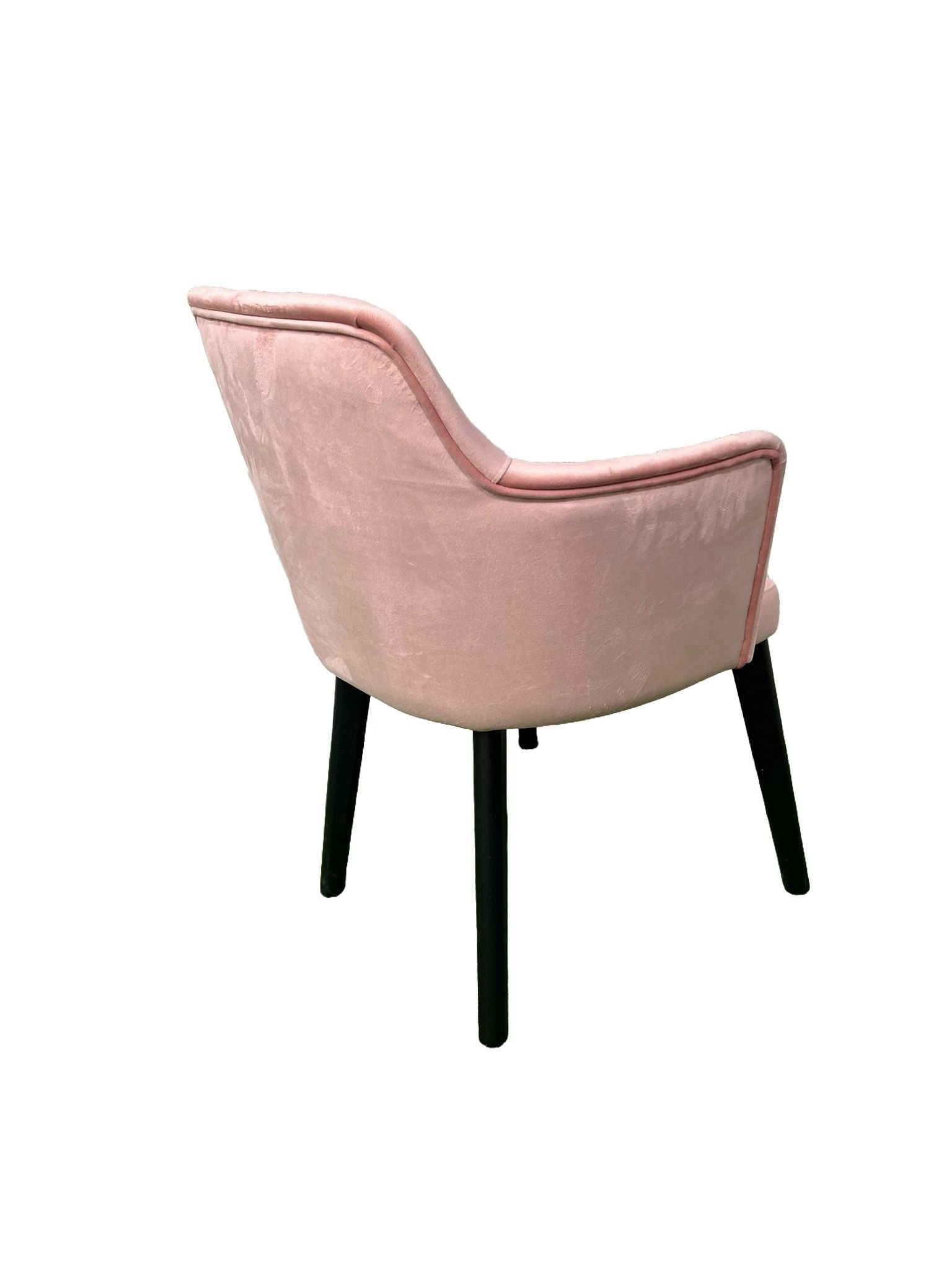 Una silla rosa con patas negras sobre un fondo blanco.