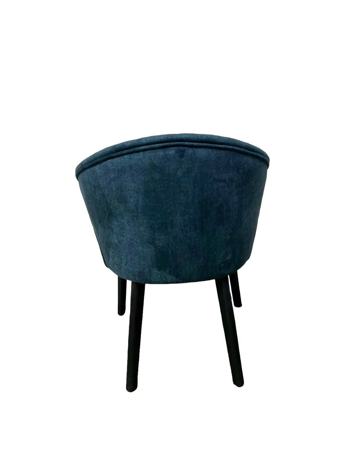 Una silla azul con patas negras sobre un fondo blanco.