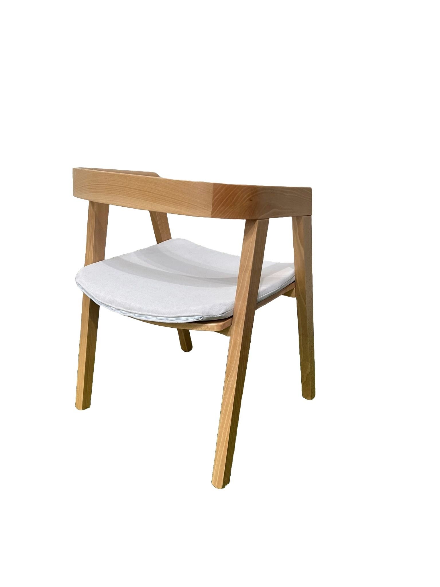 Una silla de madera con un cojín blanco sobre un fondo blanco.