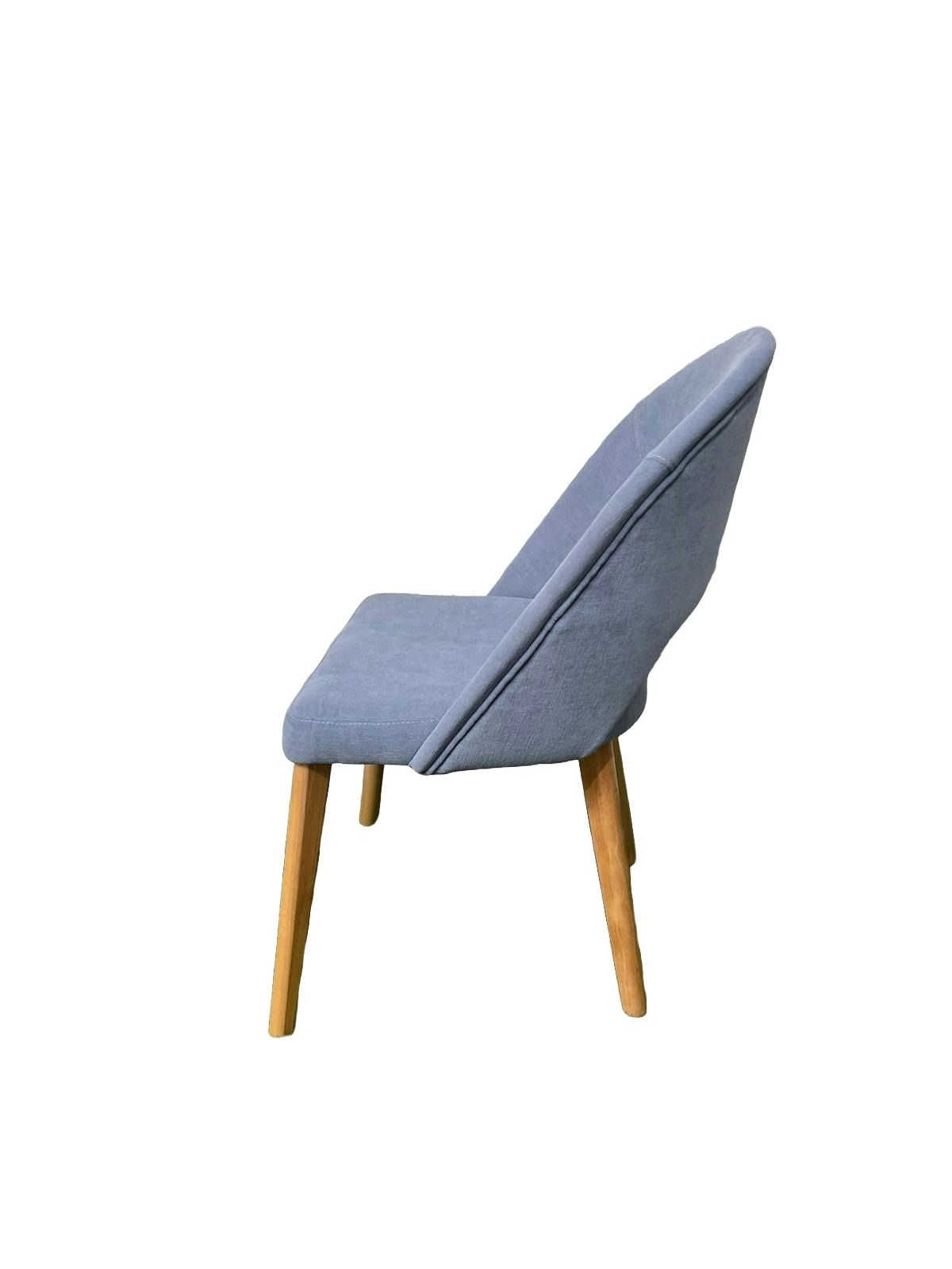Una silla azul con patas de madera sobre un fondo blanco.
