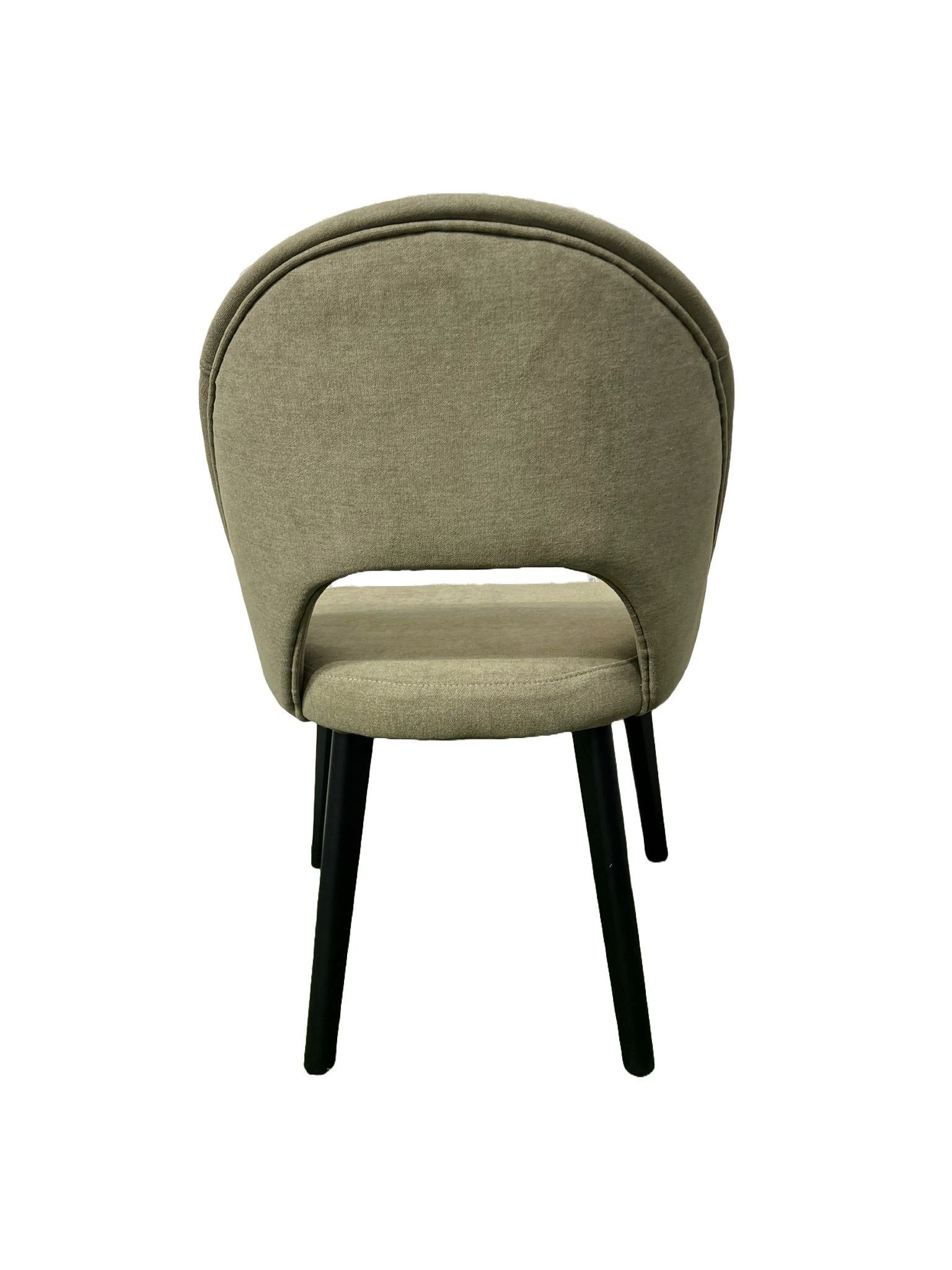 Una silla con respaldo curvado y patas negras sobre fondo blanco.