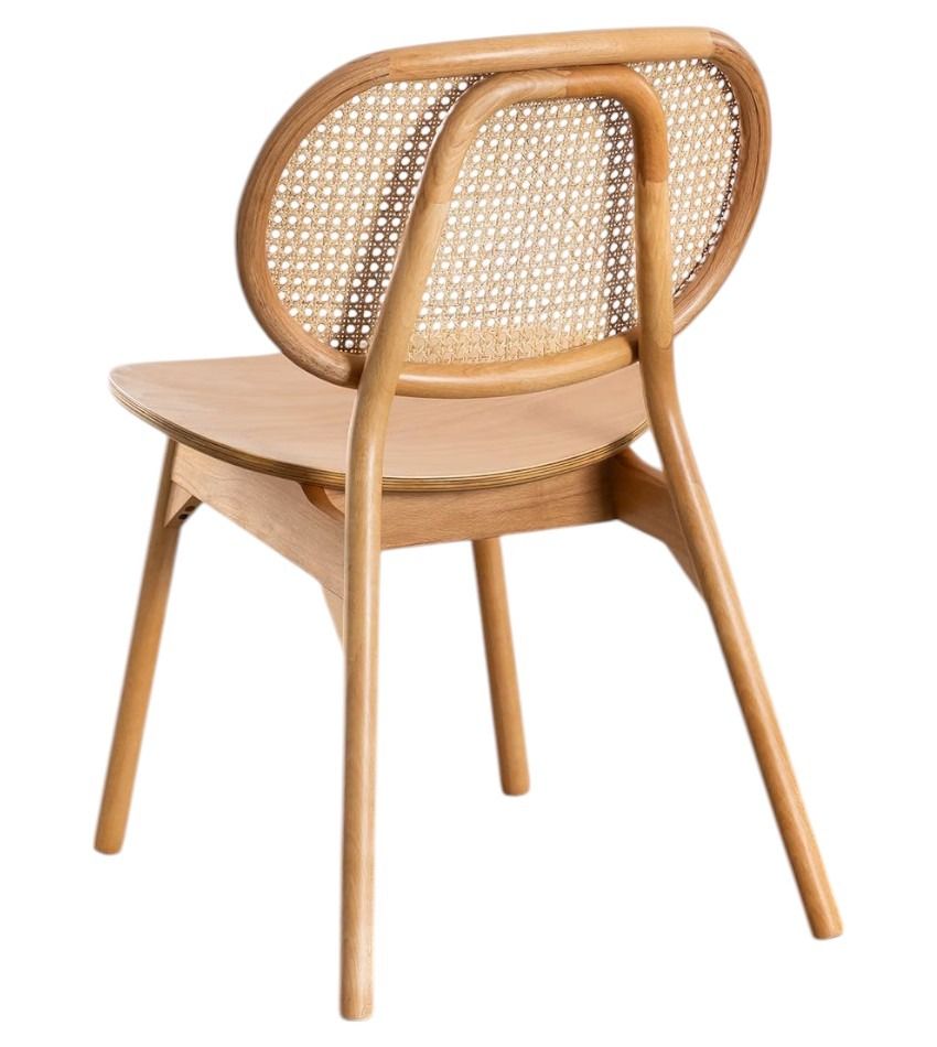 Una silla de madera con respaldo de mimbre sobre un fondo blanco.