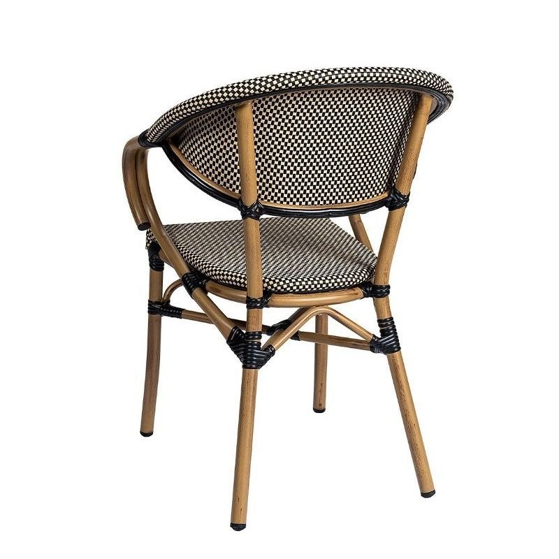 Una silla de mimbre en blanco y negro con patas de madera sobre un fondo blanco.