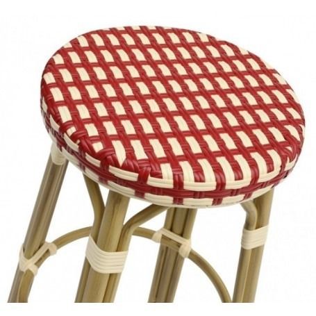 Un taburete de bar de mimbre con un tablero a cuadros rojos y blancos