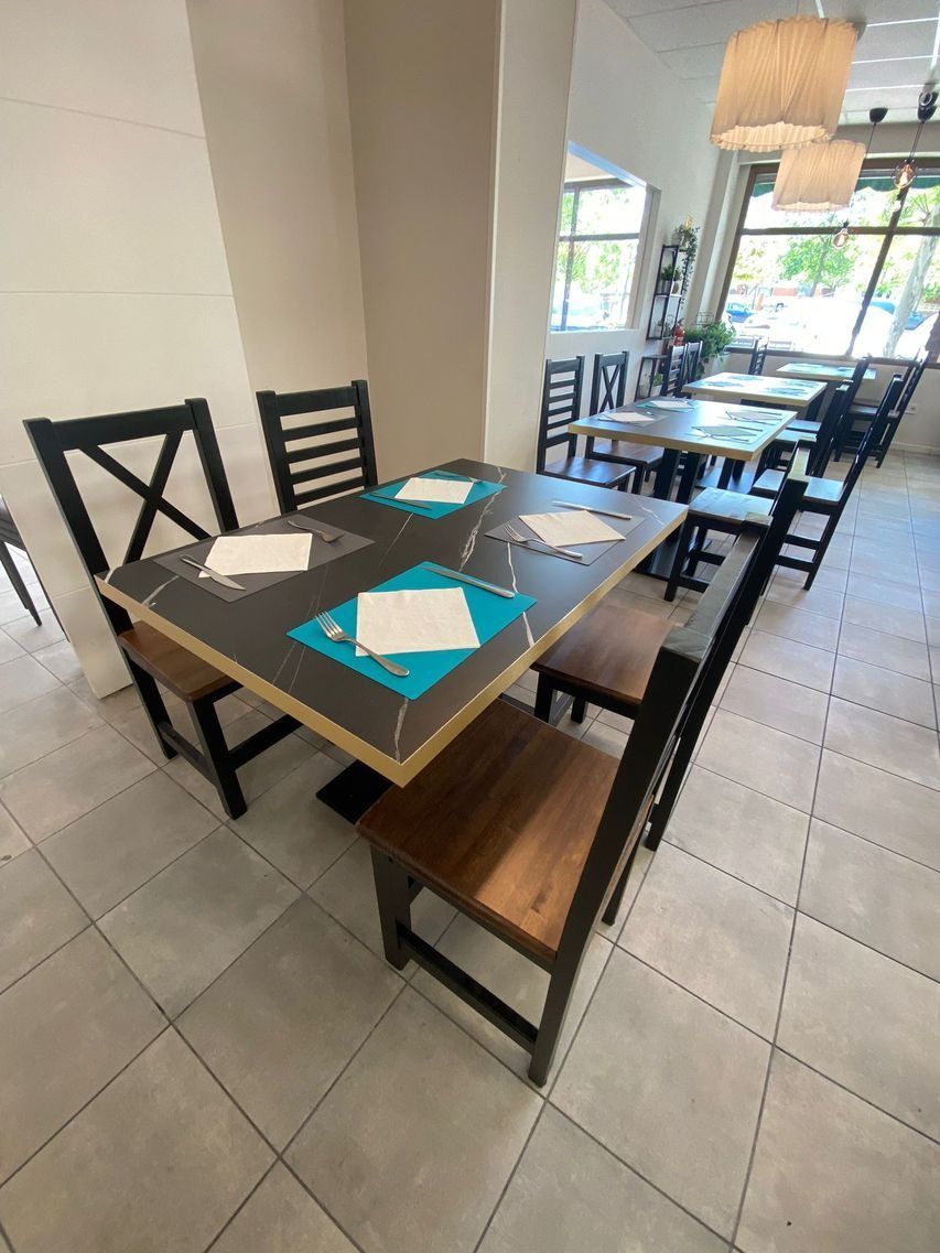 Un restaurante con mesas y sillas preparadas para comer.