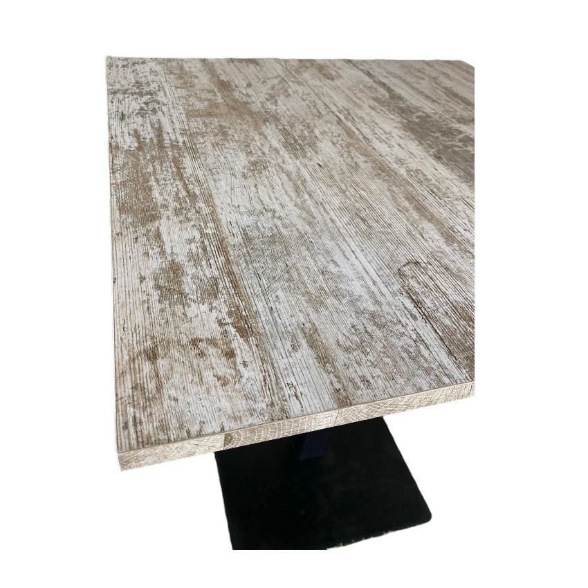 Una mesa cuadrada con base negra y tablero de madera.