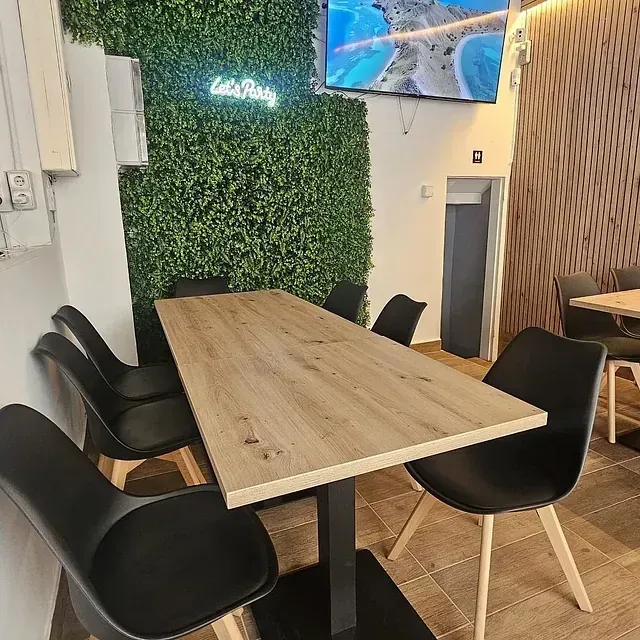Un restaurante con una mesa y sillas y un letrero de neón que dice