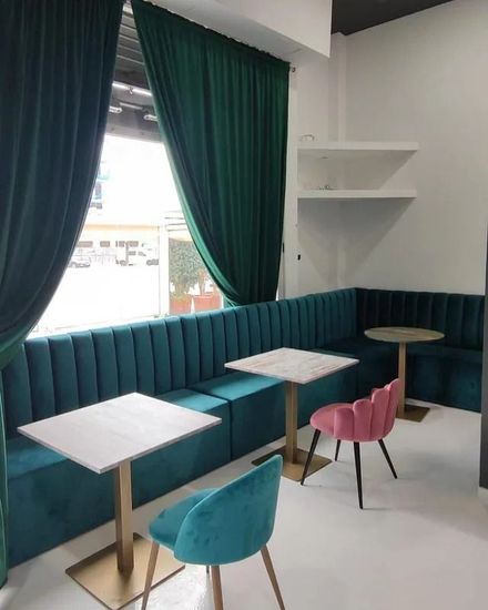 Una habitación con mesas y sillas frente a una ventana.