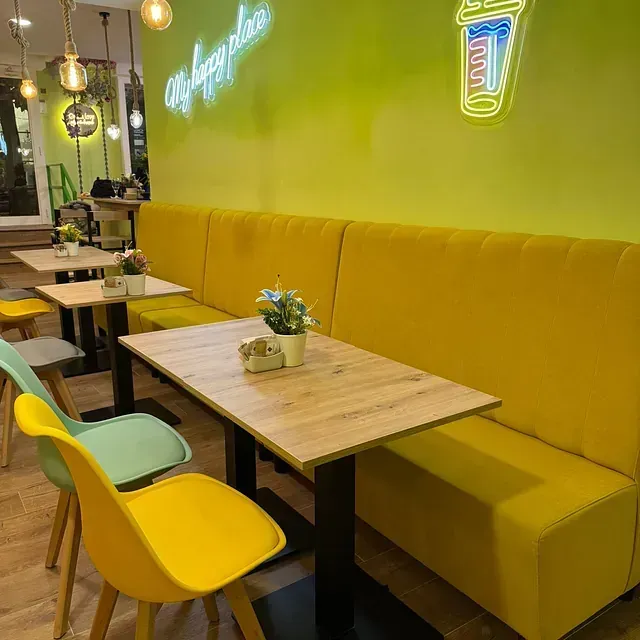 Un restaurante con mesas y sillas y un banco amarillo.