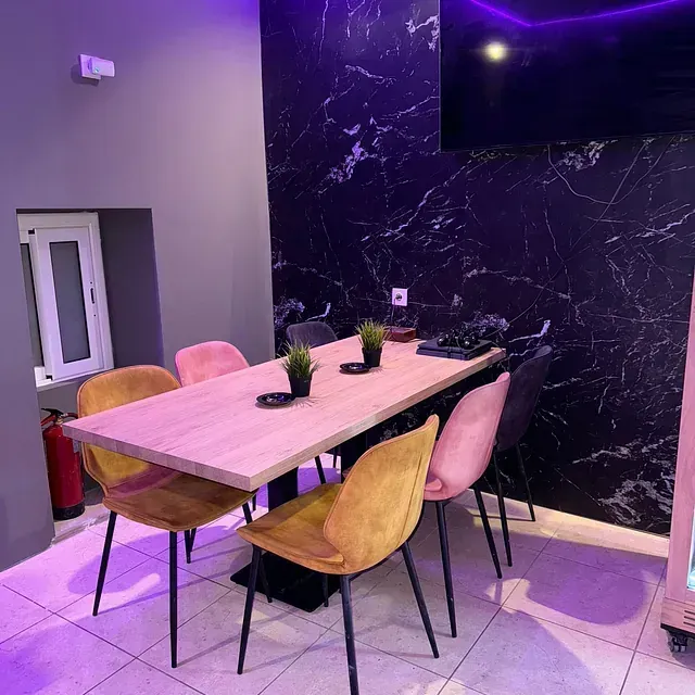 Un comedor con mesa y sillas y un televisor.