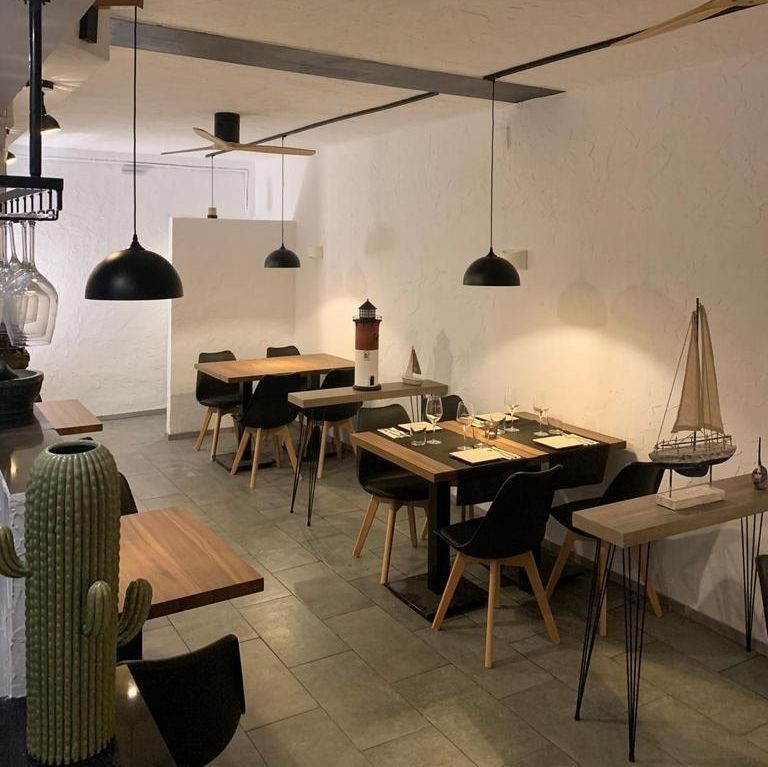 Un restaurante con mesas y sillas y un faro en la pared.