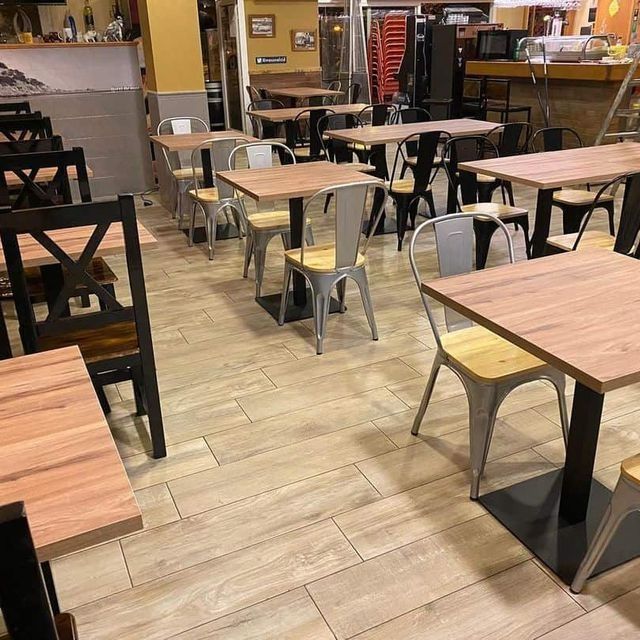 Un restaurante lleno de mesas y sillas de madera.