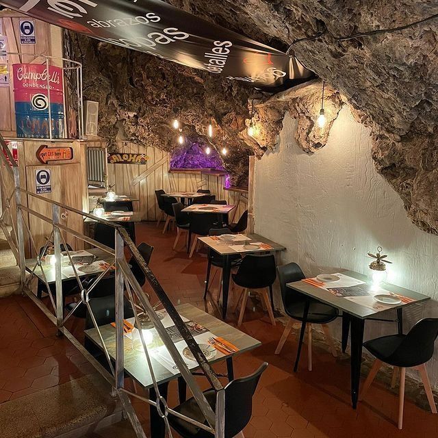 Un restaurante con mesas y sillas en una cueva.