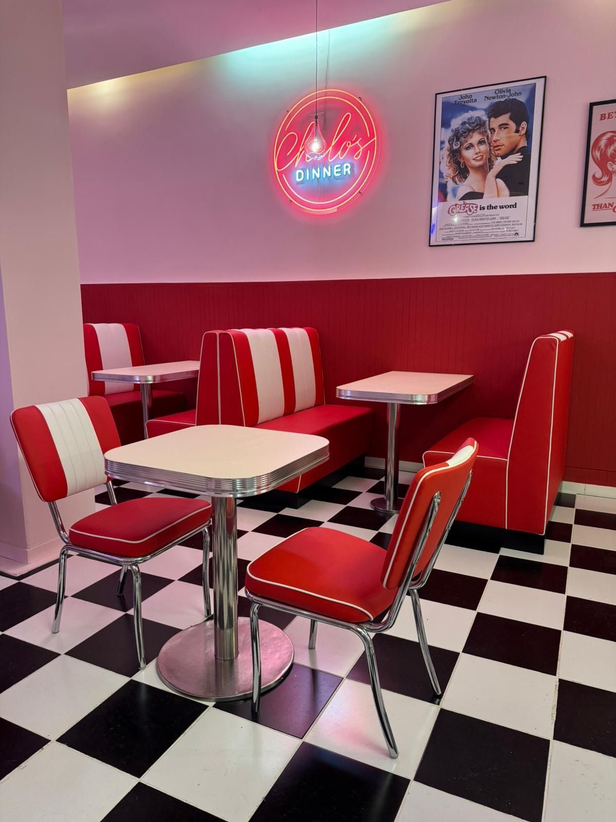 Un comedor con mesas y sillas y un suelo a cuadros.