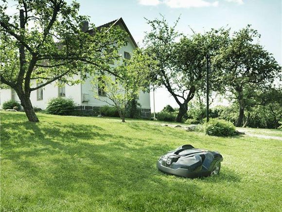 Robot tondeuse dans le jardin d'une maison