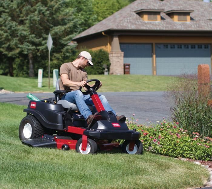 Tondeuse autoportée rouge avec un homme dessus